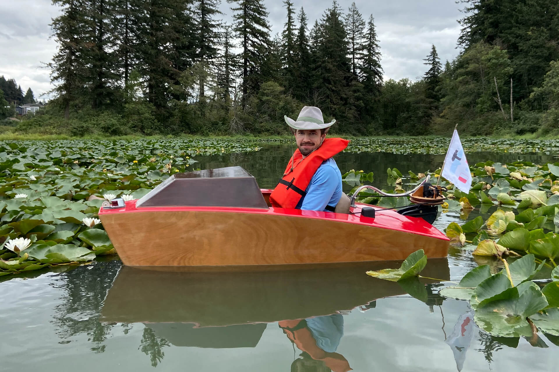 The mini boat floating in Lacamas lake, surrounded by lily pads.